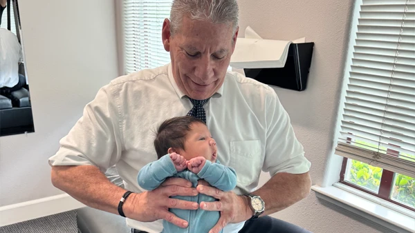 Chiropractor Holding An Infant During A Pediatric Chiropractic Visit