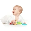 Infant Lying On A Soft Surface While Holding A Colorful Ring Toy